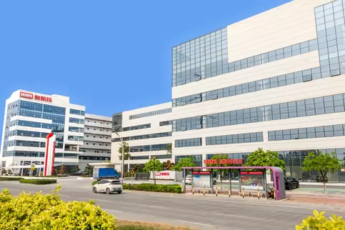 奥斯玛智能装备生产园区西大门主入口全景图，展示现代化智能工厂建筑外观，融合工业科技与建筑设计美学，体现高端装备制造企业形象，适用于企业官网品牌展示与工业园区宣传场景。