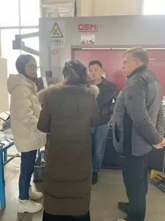 奥斯玛液压数控折弯机客户现场实拍：专业团队操作智能数控系统执行高精度钣金加工，设备采用液压同步技术与刚性机身设计，实现±0.015mm级加工精度，展现奥斯玛品牌在数控装备制造领域的专业实力与工业自动化解决方案能力