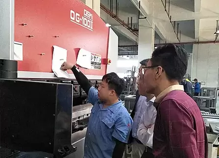 奥斯玛OG-100II下动式液压数控折弯机客户现场实拍：专业工程师操作智能数控系统，展现设备在钣金加工领域的高精度应用，液压同步技术与下动式结构确保±0.01mm级加工精度，突显奥斯玛品牌在数控装备制造领域的专业实力与技术领先性