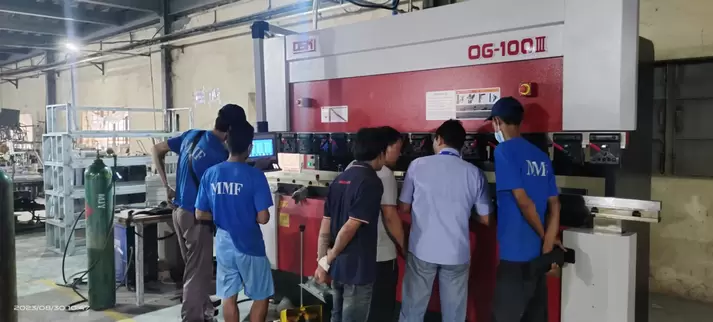 奥斯玛OG-100III下动式液压数控折弯机客户现场实拍：专业工程师操作智能数控系统，展现设备在钣金加工领域的高精度应用，液压同步技术与下动式结构确保±0.01mm级加工精度，突显奥斯玛品牌在数控装备制造领域的专业实力与技术领先性