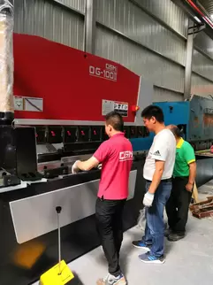 奥斯玛OG-100II下动式液压数控折弯机客户现场实拍：专业工程师操作智能数控系统，展现设备在钣金加工领域的高精度应用，液压同步技术与下动式结构确保±0.01mm级加工精度，突显奥斯玛品牌在数控装备制造领域的专业实力与技术领先性