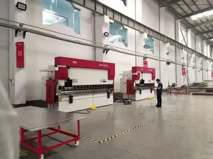 奥斯玛HP-11040液压数控折弯机客户现场实拍：专业工程师操作1100吨级液压折弯设备，搭载智能数控系统与双缸同步技术，实现4米超长板材一次性精密成型，加工精度达±0.02mm，展现高端数控装备在重型钣金制造领域的核心应用价值
