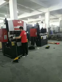奥斯玛OG-35II下动式液压数控折弯机客户现场实拍：专业技师操作智能数控系统执行精密钣金折弯作业，设备采用液压同步技术与下动式结构，实现±0.015mm加工精度，突显奥斯玛品牌在中小型数控装备领域的专业实力与技术革新