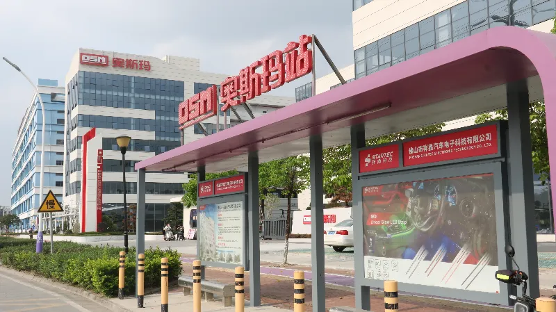 奥斯玛智能装备工厂正门及奥斯玛站站台标识，展示企业规模与品牌形象，体现智能制造基地实力。